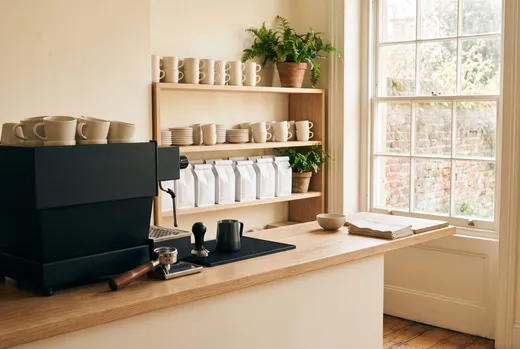 Morning light across the counter and the shelf of house-roasted beans
